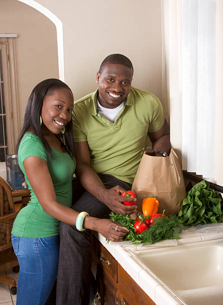 istock Young ethnic couple on kitchen sorting groceries 146781820