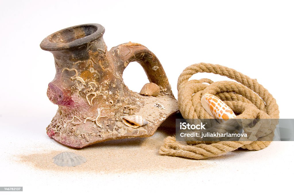 Still-life with broken amphora and rope Shiver of ancient vase covered with seashells and hank of rope isolated on white Amphora Stock Photo