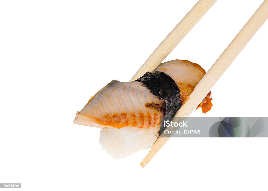 chopsticks and sushi with eel macro photo of sushi and chopsticks isolated on white background Chopsticks Stock Photo