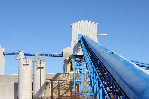 Cement Factory Conveyor Close-up of a conveyor at a cememt factory against a blue sky cement factory stock pictures, royalty-free photos & images