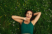 Smiling young woman lying on grass