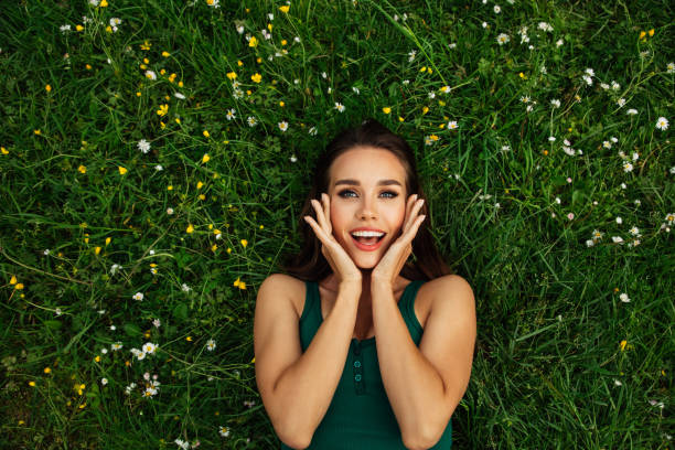istock Smiling young woman lying on grass 1467823905
