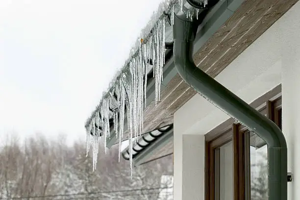Photo of Icicles hanging from the roof of a house
