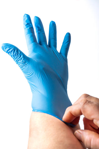 istock woman putting on blue latex gloves 1467825157