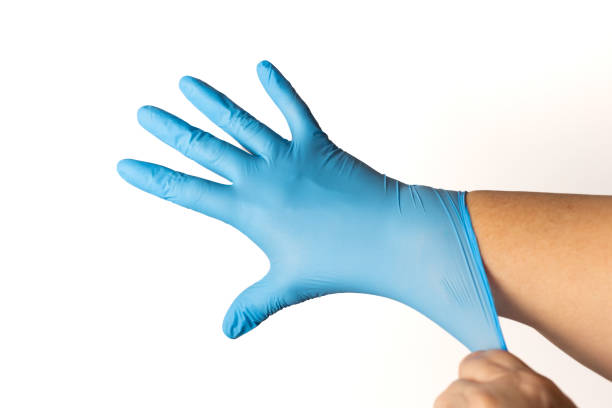 istock woman putting on blue latex gloves 1467825162