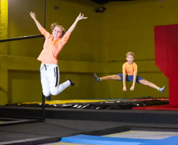 Photo of Teenage girl having fun jumping in indoor trampoline arena