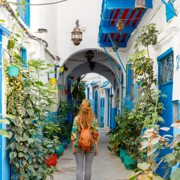 turismo en Tánger, mujer caminando por la típica calle marroquí - foto de stock