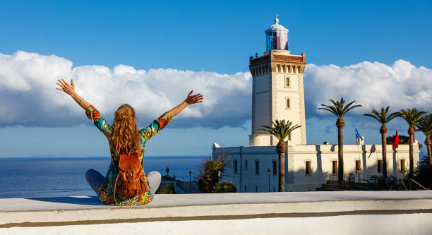 Woman tourist looking at lighthouse of Cap Spartel,  Tanger,  Morocco in Africa stock photo