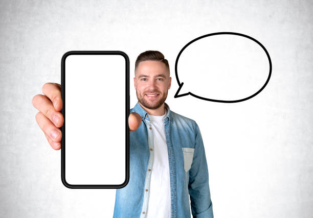 istock Happy man holding a big phone with blank display, empty speech bubble 1467835460