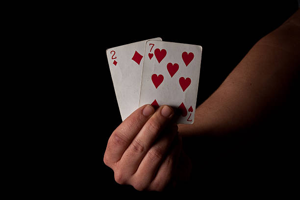 Man Holding Bad Cards - Two and Seven stock photo