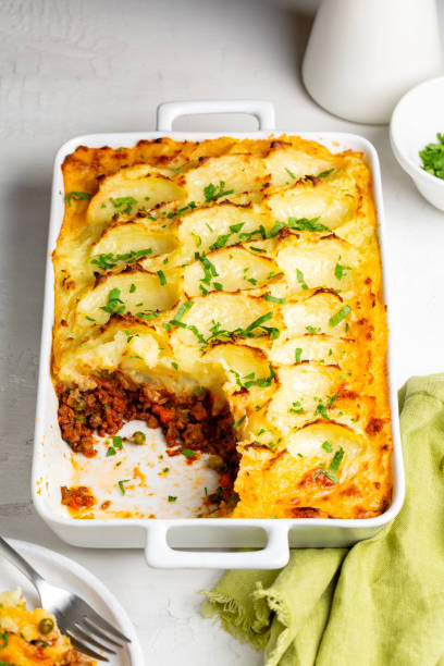 istock Shepherd's pie, or cottage pie, or French version hachis Parmentier. Cooked minced beef meat with vegetables, green pea, carrot, onion,  topped with mashed potato with cheese and baked. 1467846730