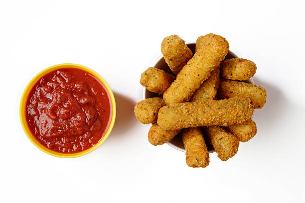 Pile of fried cheese sticks with marinara sauce Crispy fried cheese sticks with tomato sauce. marinara stock pictures, royalty-free photos & images