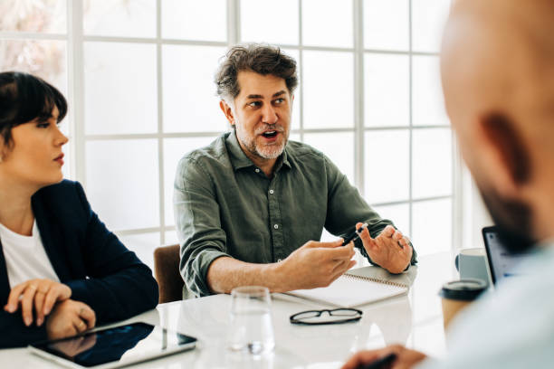 istock Senior business man discussing with his team, giving solutions and ideas 1467848398