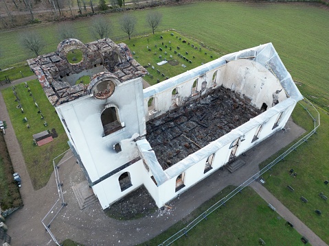 Aerial view of a house destroyed by a fire, revealing charred remains of the structure