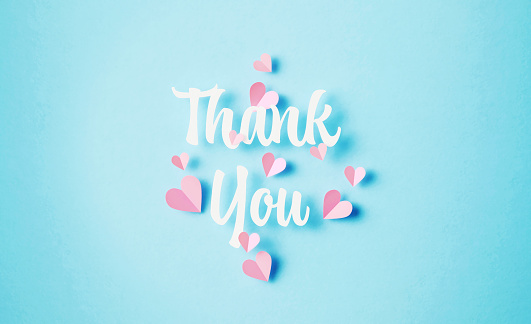 Thank You phrase surrounded by pink hearts on blue background. Horizontal composition with copy space.