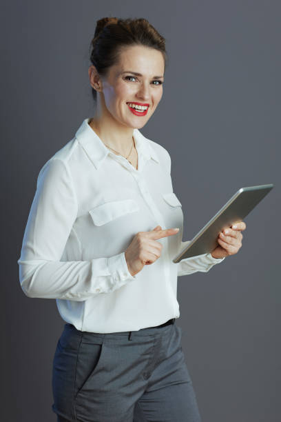 istock happy female employee using applicationst PC isolated on grey 1467859361