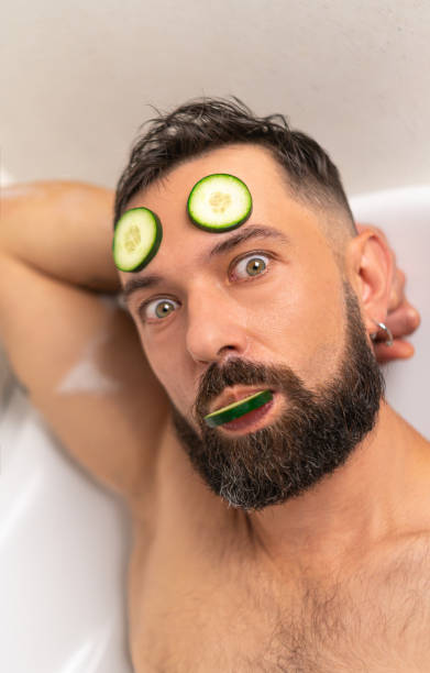 istock Funny man with cucumber on his face in bath at home 1467859637