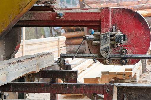 The process of processing logs on the equipment of a sawmill.