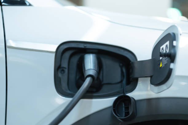istock Power cable pump plug in charging power to electric vehicle EV car. 1467862237