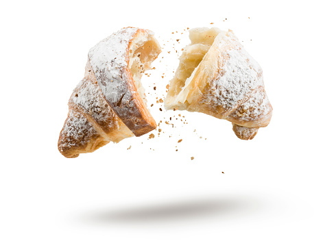 Croissant with sugar open in half floating on white background.