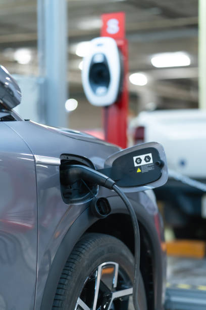 istock Power cable pump plug in charging power to electric vehicle EV car. 1467862588