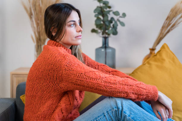 istock Smiling woman sitting on sofa 1467863839