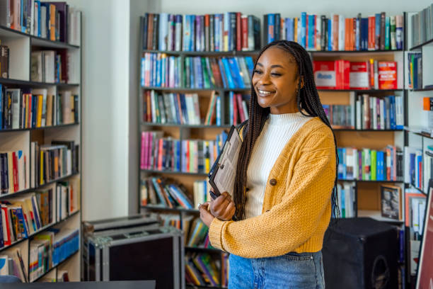istock Female teacher looking at away in library 1467864024