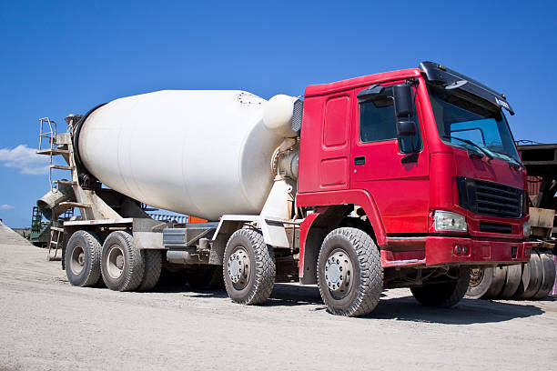 istock Red and white cement mixer on gravel road under blue sky 146786421