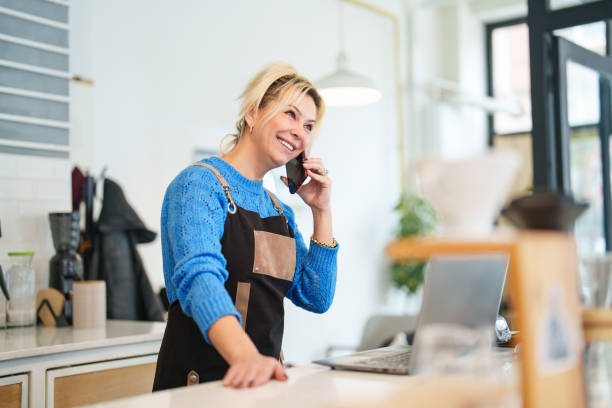 istock Coffee Shop Business Owner Talking on Phone at Work 1467868139