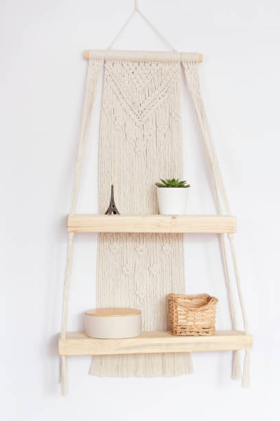 istock Wall decor in ecological boho, Scandinavian style. Wooden shelves in the macrame technique. Interior decor close-up. Macrame decor on a light background. 1467868282