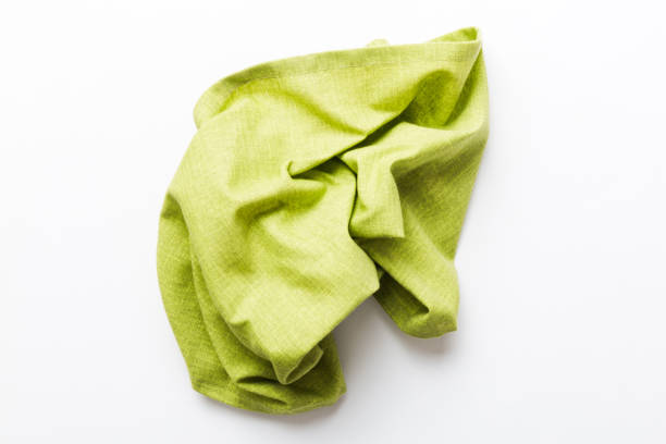 istock top view with green kitchen napkin isolated on table background. Folded cloth for mockup with copy space, Flat lay. Minimal style 1467869949
