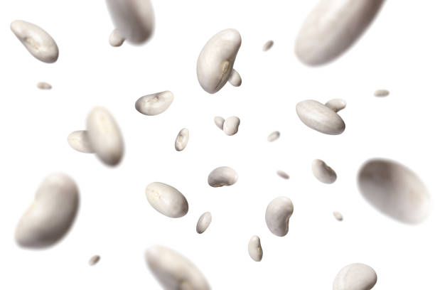butter beans flying and falling in the air on white