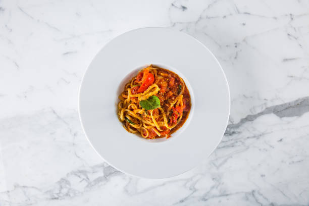 istock Spaghetti with tomato sauce, pepper cheese and basil in a plate on a marble background 1467871123