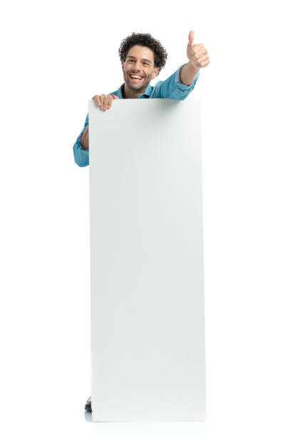 istock happy arab man covering his body with empty board and laughing 1467876100