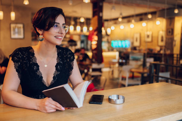 istock Woman reading a book while relaxing in the cafe or a bookstore 1467876276