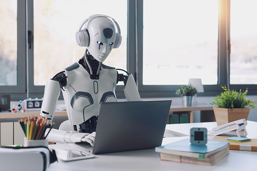 A humanoid robot works in an office on a laptop to listening Music in  Headphone, showcasing the utility of automation in repetitive and tedious tasks.