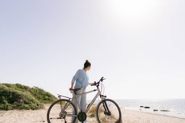 istock Young woman exploring coastline on a bicycle 1467880155