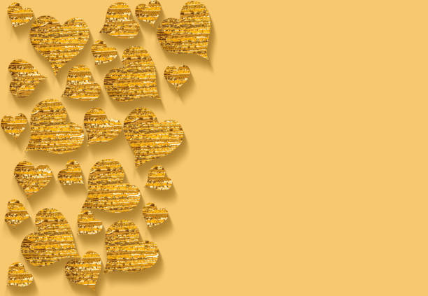golden metallic hearts in different sizes on yellow  background