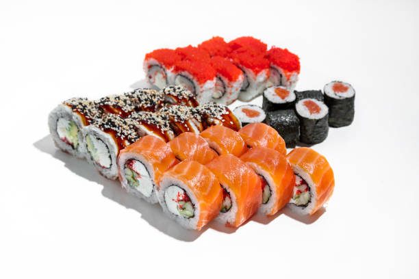 Red sushi set. Four sushi rolls stand on a white background. Philadelphia sushi with trout sashimi, maxi sushi with salmon, sushi with tuna and ugem and sushi with shrimp and flying fish caviar tobiko.