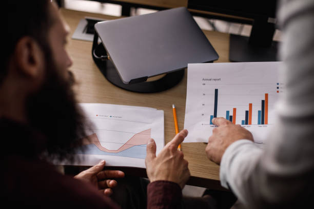istock Two male coworkers engage in a deep discussion as they analyze a document 1467882567