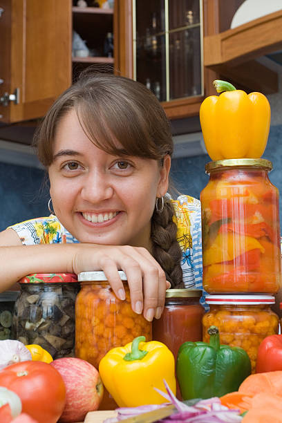 Girl with vegetables and jars Girl with vegetables and jars in the kitchen pattyson stock pictures, royalty-free photos & images
