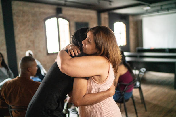 istock Mature woman embracing and giving support during group therapy 1467884481