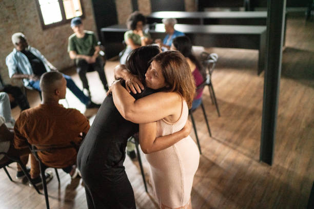 istock Mature woman embracing and giving support during group therapy 1467884482