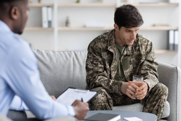 istock Thoughtful military man looking away during therapy session with psychologist 1467885649