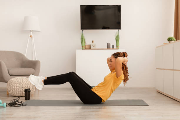 istock Side View Of Woman Exercising Doing Abs Crunches At Home 1467885750