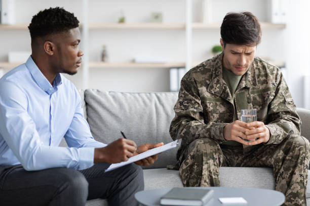 istock Upset soldier having therapy session with psychologist, clinic interior 1467886602