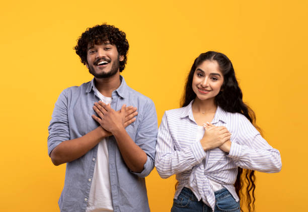 istock Thankful indian couple keeping both palms on chest, smiling at camera, expressing appreciation and kindness 1467886672