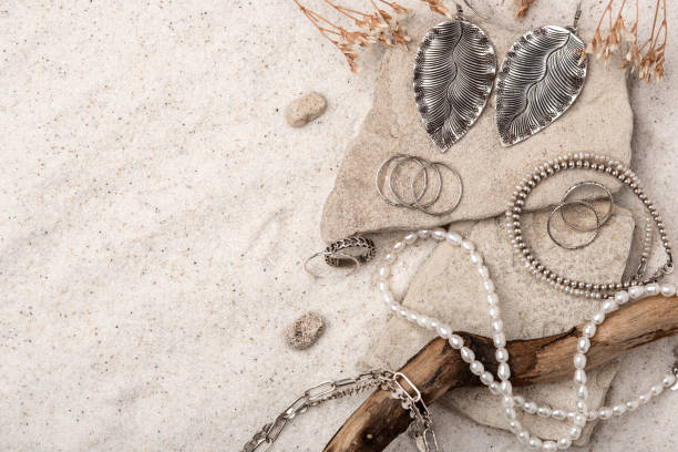 schöner silber- und perlenschmuck auf weißem sand. - pearl necklace earring jewelry stock-fotos und bilder