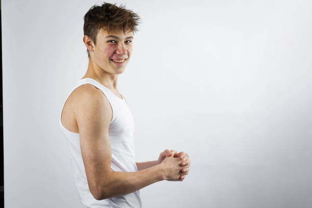 A 17 year old teenage boy wearing a white tank top