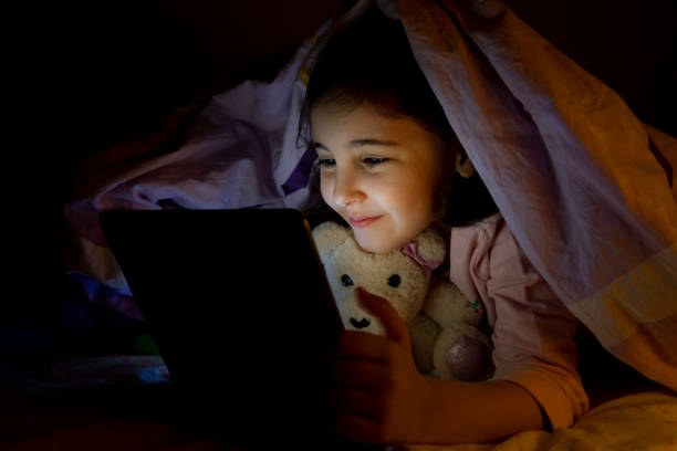 istock Little girl using digital tablet in her bed at night 1467889558